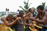 Des adeptes du vaudou s'aspergent d'eau bénite lors d'une cérémonie de purification à Bè, un quartier populaire de Lomé, le 7 juillet 2017