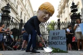 Un manifestant portant un masque représentant le Premier ministre britannique Boris Johnson manifeste devant les bureaux de ce dernier à Downing Street en installant une fausse pierre tombale, le 28 août 2019 à Londres.
