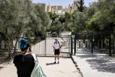 Un touriste pose devant l'entrée de l'Acropole fermée pour cause de canicule à Athènes, le 14 juillet 2023