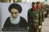 Des membres d'une force paramilitaire chiite au garde à vous devant le portrait de l'ayatollah Ali Sistani, le 30 août 2019 à Kerbala, en Irak