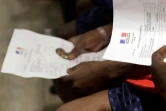 Des réfugiés du Lifeline tiennent entre leur main le "Laissez-Passer Europeen", le 5 juilllet 2018 à Roissy