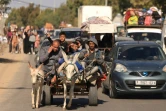 Des Palestiniens transportant leurs affaires fuient après l'avertissement de l'armée israélienne de quitter leurs maisons et de se déplacer vers le sud avant une offensive terrestre, le 13 octobre 2023 à Gaza