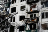 Les pompiers tentent d'éteindre un incendie dans un immeuble après un bombardement à Tchouhouïv (Ukraine) le 24 février 2022