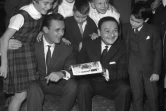 Le dessinateur Albert Uderzo à gauche et son complice le scénariste de bande dessinée René Goscinny posent au milieu du jury d'enfants pour la remise du "Prix Collégien" à Paris en 1962