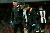 Le défenseur irlandais de Newcastle, Ciaran Clark (c), blessé, quitte la pelouse soutenu par son équipe médicale lors du match de Premier League face à Arsenal, à Londres, le 16 février 2020
