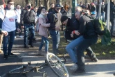 Un manifestant et un contre-manifestant se battent lors d'un défilé contre les restrictions destinées à lutter contre le Covid-19, à Vienne (Autriche), le 6 mars 2021.