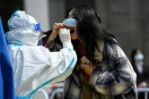 Une femme se fait tester pour le coronavirus dans un centre de dépistage installé devant des immeubles de bureau à Pékin, le 29 avril 2022