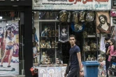 Un homme passe devant une boutique d'objets et de bibelots religieux, dans le quartier de la Choubra, le 11 avril 2017 au Caire, en Egypte