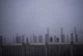 Des ouvriers du bâtiment travaillent, environnés par un brouillard blanchâtre provoqué par la pollution,à Shtime, au Kosovo, le 16 janvier 2020.
