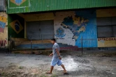 Un passant le 20 août 2018 devant un abri utilisés par des réfugiés vénézuéliens et incendiés par des villageois, à Pacaraima, au Brésil