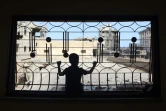 Un enfant palestinien regarde par la fenêtre d'une maison endommagée à Khan Younès, ville du sud de la bande de Gaza transformée en champ de ruines par les bombardements israéliens et les combats, le 30 juin 2024
