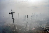 Des croix sous la fumée d'une poubelle dans le cimetière de Mykolaïv, dans le sud de l'Ukraine, le 21 mars 2022