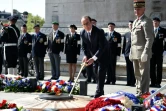 Le président François Hollande ravive la flamme éternelle sur la tombe du soldat inconnu, pour la cérémonie du 8 mai 2016 à Paris