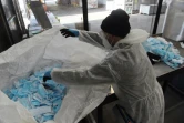 Un employé de Greenwishes trie des masques usagés dans un centre de recyclage, le 19 avril 2021 à Gennevilliers, près de Paris