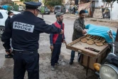 Un policier ordonne à un vendeur de pain de remballer sa marchandise et de rentrer chez lui, le 27 mars 2020 à Rabat pendant l'épidémie de coronavirus