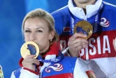 Les Russes Tatiana Volosozhar et Maxim Trankov sur le podium des Jeux olympiques de Sotchi le 13 février 2014 avec leur médaille d'or remportée en couple