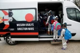 Des élèves de l'Ecole Vivalys en costume spatial montent dans un bus lors du projet ?Mission pour Mars? à Lausanne (Suisse) le 17 mars 2021