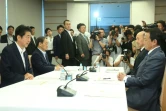 Le Premier ministre japonais Shinzo Abe (G) lors d'une réunion avec son ministre des Finances Taro Aso (D) et un haut responsable de la Banque du Japon le 27 juin 2016 à Tokyo