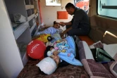 Des enfants blessés dans des frappes israéliennes attendent dans une ambulance leur évacuation vers les Emirats Arabes Unis via l'Egypte, le 17 novembre 2023 à l'hôpital al-Aqsa de Deir al-Balah, dans la bande de Gaza