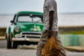 Un homme porte ses achats dans une rue de La Havane, le 3 mai 2021 à Cuba