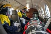 Un médecin et une infirmière prennent soin d'un patient atteint du coronavirus, enfermé dans une "capsule de protection", à bord d'un avion-ambulance à destination de Lima, le 1er septembre 2020 à l'aéroport d'Iquitos, au Pérou