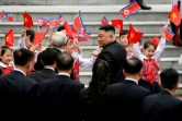 Le dirigeant nord-coréen Kim Jong Un (D) et le président vietnamien Nguyen Phu Trong (G) salués par des enfants lors d'une cérémonie d'accueil au palais présidentiel à Hanoï, le 1er mars 2019