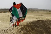 Un jeune Palestinien tient un cerf-volant aux couleurs palestiniennes près de la frontière entre la bande de Gaza et Israël, 20 avril 2018