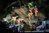 Des pompiers fouillent une maison touchée par un glissement de terrain à Gamagori, dans la préfecture d'Aichi, le 28 août 2024 au Japon