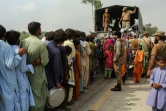 Des militaires procèdent à une distribution de nourriture pour des sinistrés après de violentes pluies de mousson, le 27 août 2022 à Rajanpur (Pakistan)