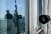 Seo Seung-ho nettoie les vitres du plus haut gratte-ciel de Séoul, le Lotte World Tower, depuis une "nacelle" suspendue par des câbles au 125e étage du bâtiment, le 4 juin 2024 à Séoul, en Corée du Sud