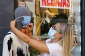 Une vendeuse place un masque sur un mannequin à Aranda de Duero, le 7 août 2020 en Espagne