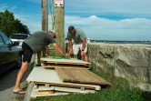 Deux membres d'une association de plage privée démontent une cahute de plage en prévision du passage de l'ouragan Henri, à New London (Connecticut), le 21 août 2021