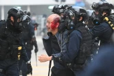 Des policiers arrêtent un homme blessé après avoir dispersé une manifestation sur la place de Chater Garden, à Hong Kong le 19 janvier 2020