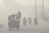 Des Pakistanais se rendent au travail dans la ville de Lahore recouverte d&rsquo;un épais smog, le 5 juin 2022