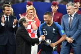 L'attaquant des Bleus Kylian Mbappé reçoit le trophée de meilleur jeune du Mondial des mains du président de la FFF Noël Le Graët, le 15 juillet 2018 à Moscou