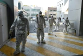 Des agents sanitaires désinfectent les abords d'une église où des cas de coronavirus ont été détectés, le 19 février 2020 à Namgu, en Corée du Sud