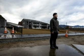 Yuto Naganuma, 26 ans, devant les bâtiments endommagés de l'école primaire où son petit frère a perdu la vie pendant le tsunami de 2011, le 7 février 2021 à Ishinomaki, au Japon