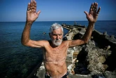 Orestes Quintana, 87 ans, membre du club "Jeunesse accumulée", s'échauffe avant de nager dans une piscine d'eau de mer à La Havane, le 17 mai 2025