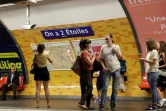 Des passagers du métro de Paris photographient l'affiche "On a deux étoiles", en référence à la 2e Coupe du Monde de la France, à la station de l'Etoile le 16 juillet 2018