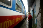 Un touriste regarde passer un train dans le vieux quartier de Hanoï le 20 octobre 2018.
