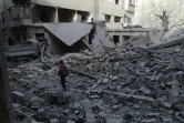 Un garçon marche au milieu des immeubles détruits par les bombardements du régime syrien à Douma dans la Ghouta orientale, le 19 mars 2018