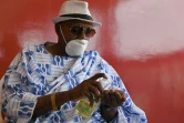 Le chef du village d'Azaguie, Nanan Ako Ako Omer, se désinfecte les mains lors d'une réunion avec des notables sur la campagne de lutte contre l'épidémie du nouveau coronavirus, le 27 mars 2020 en Côte d'Ivoire