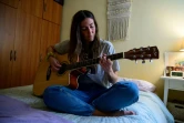 Cristina Rios, médecin, joue de la guitare dans sa chambre, dans l'appartement qu'elle partage avec ses trois consoeurs, le 4 mai 2020 à Madrid