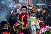 Des enfants, maquillés et habillés de costumes bordés et colorés, en parade, debout sur des palanquins, dans les rues de Tufang, le 11 février 2017 dans l'est de la Chine
