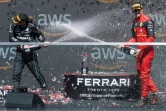 Les pilotes espangol Carlos Sainz (d) et britannique Lewis Hamilton s'arrosent de champagne pour fêter leurs 2e et 3e place au Grand Prix du Canada, le 19 juin 2022 à Montréal