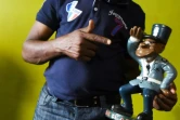 L'acteur ivoirien Michel Gohou pose avec une statue du gendarme de Abobo, à Abidjan le 20 novembre 2019.
