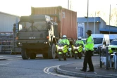 Des policiers britanniques escortent un camion qui transporte la voiture de Sergueï Skripal, l'ex-agent russe emprisonné à Salisbury, en Angleterre, le 16 mars 2018