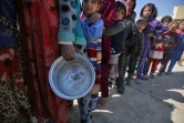 Des civils en file d'attente pour une distribution de nourriture le 10 mars 2017 à Tal al-Rumman dans la banlieue de Mossoul