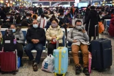 Des passagers équipés de masques de protection attendent leur train pour aller voir leur famille à l'occasion du Nouvel An chinois, à Shanghai le 23 janvier 2020
