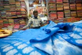 Un vendeur montre des saris traditionnels dans une boutique de Varanasi, le 20 novembre 2021 en Inde